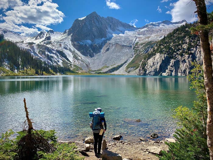 Person with backpack on at a lake in the mountains
