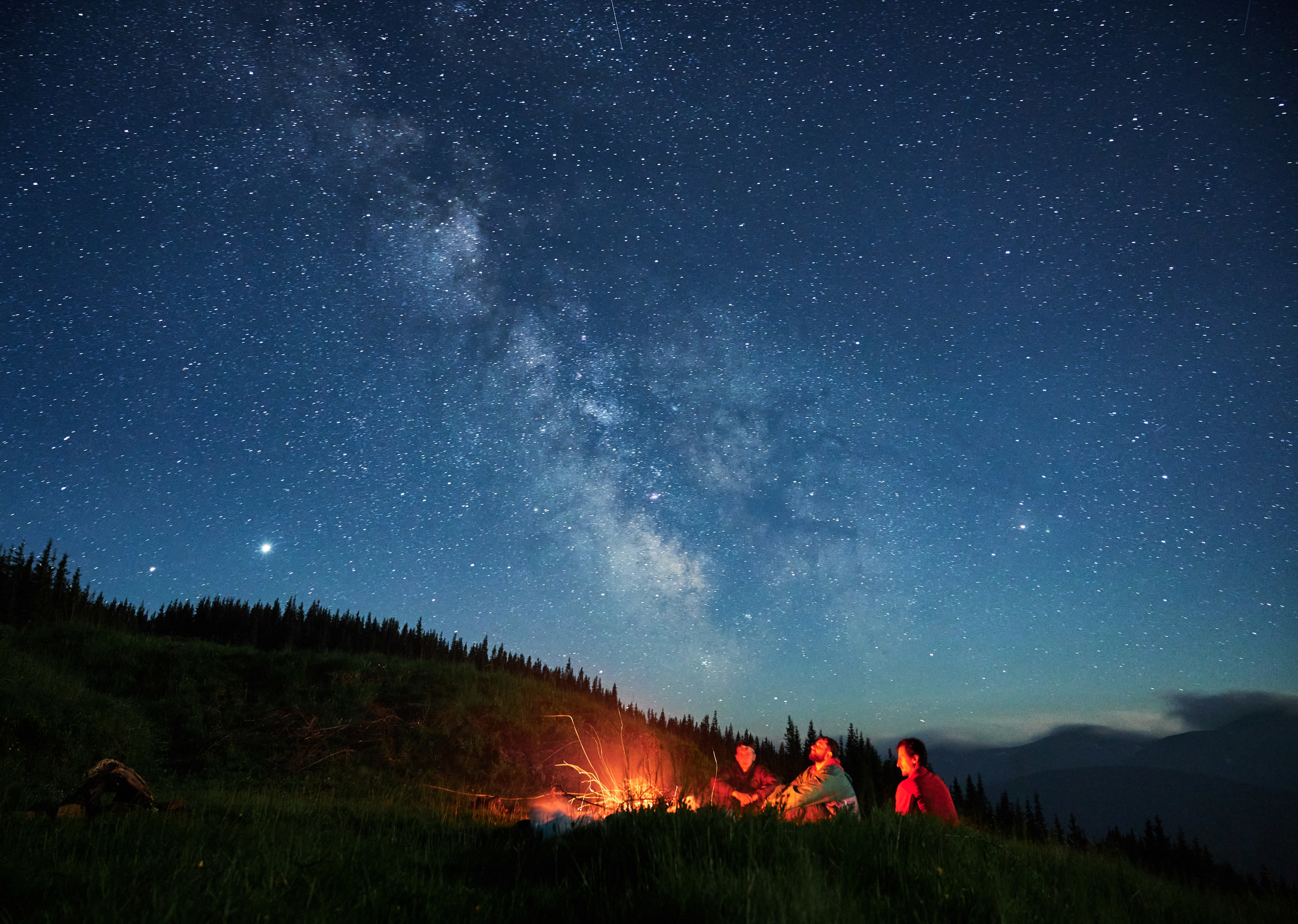 People around a campfire under a starry sky
