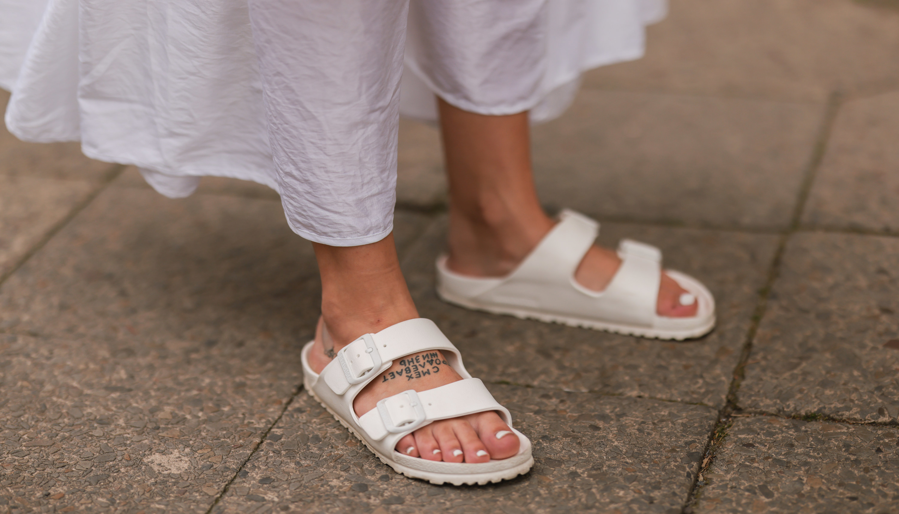 Woman wearing white Birkenstocks