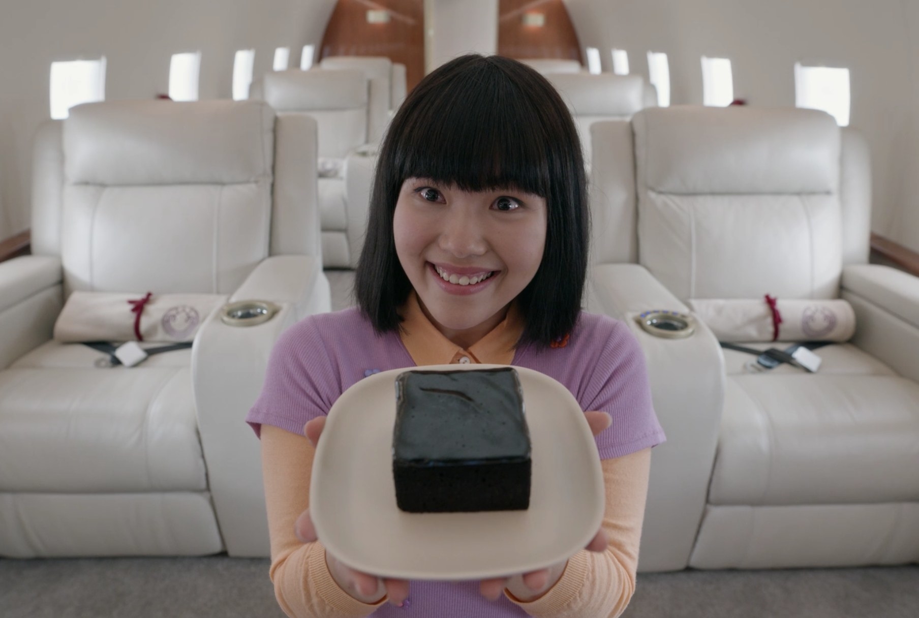 Linh holding a piece of cake on the plane in &quot;The Wilds&quot;