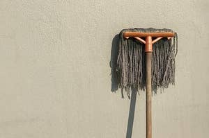 A gross mop leaning on a wall