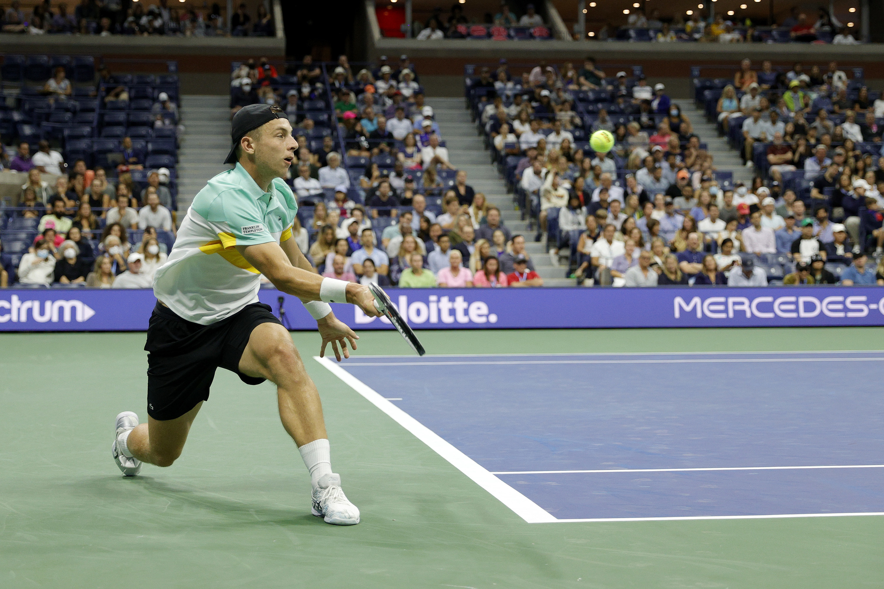 Tallon Griekspoor, a tennis player volleys a tennis ball on a court.