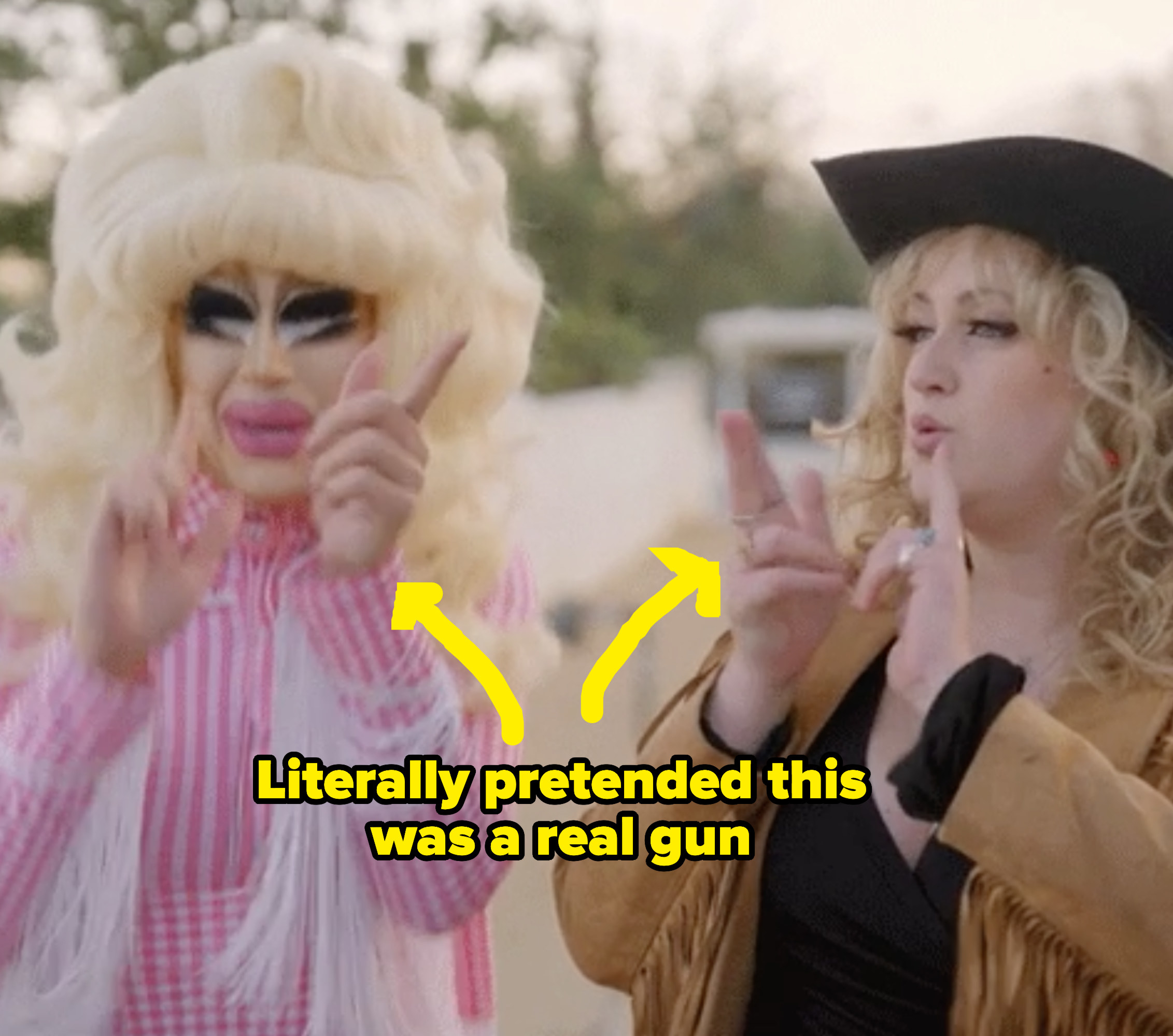 A drag queen and woman with finger guns