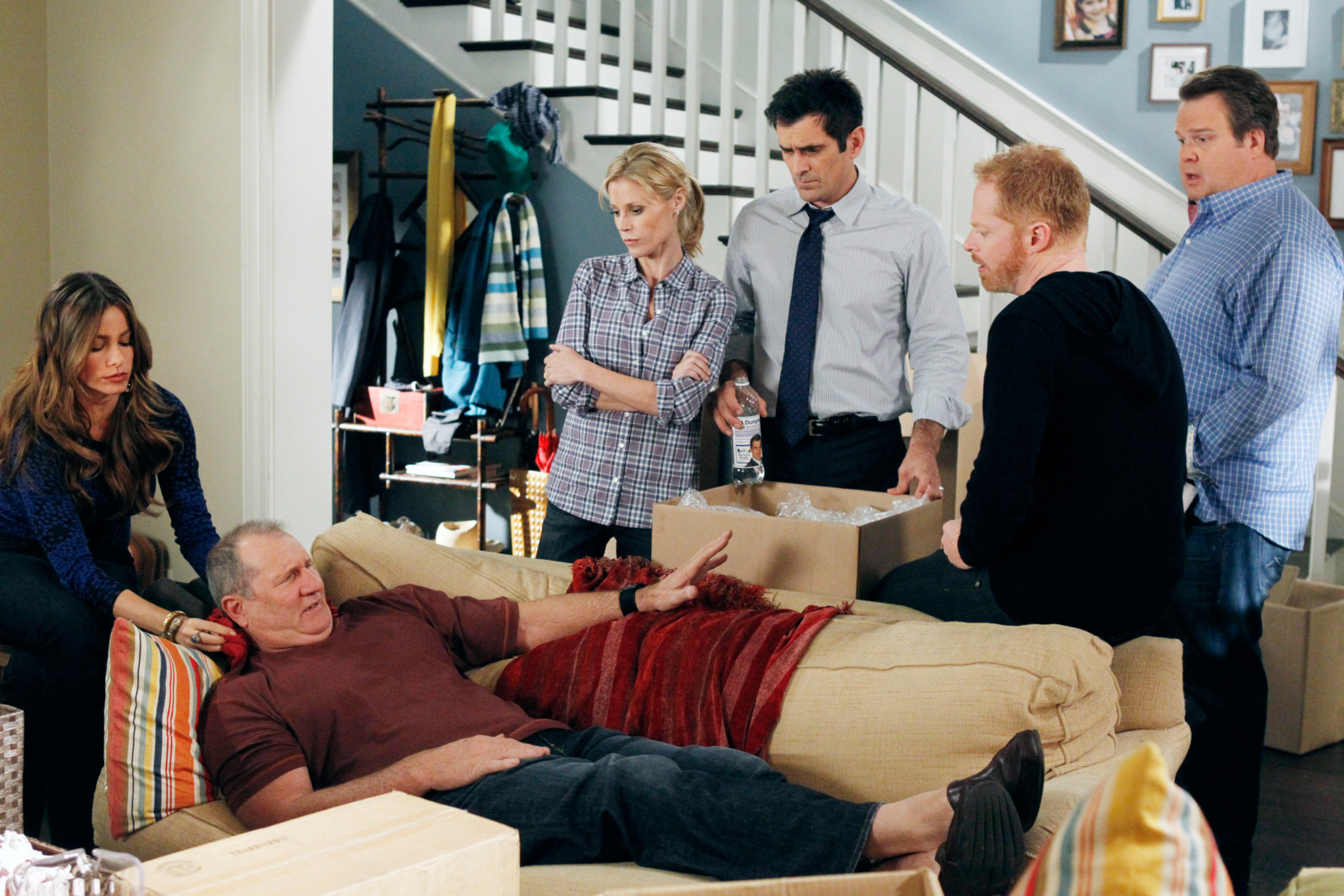the characters surrounding the dad as he lies in pain on the couch