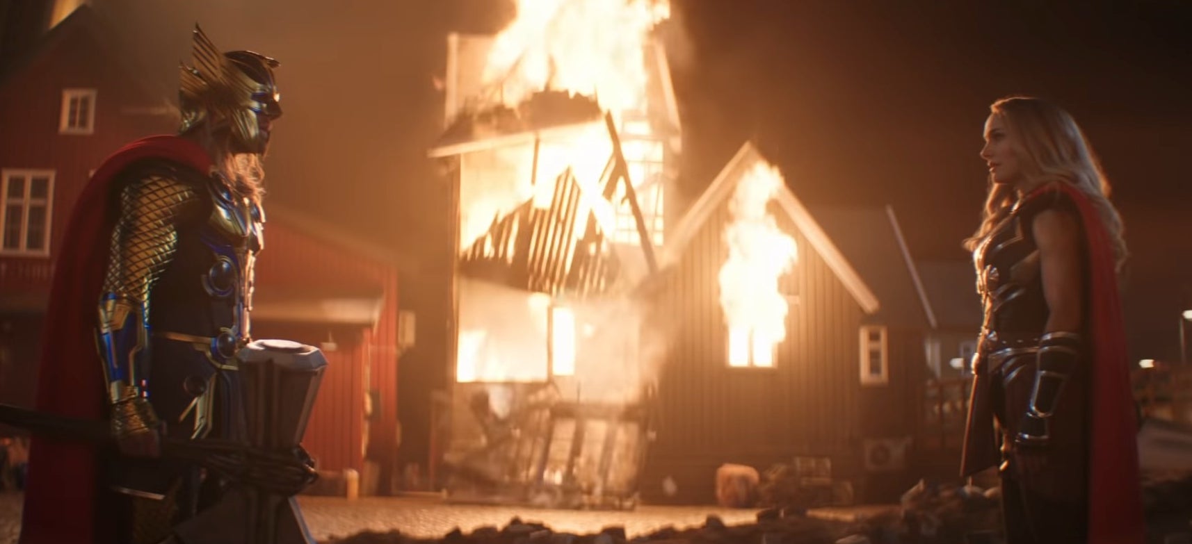 Thor and Jane standing next to a burning building in &quot;Thor: Love and Thunder&quot;