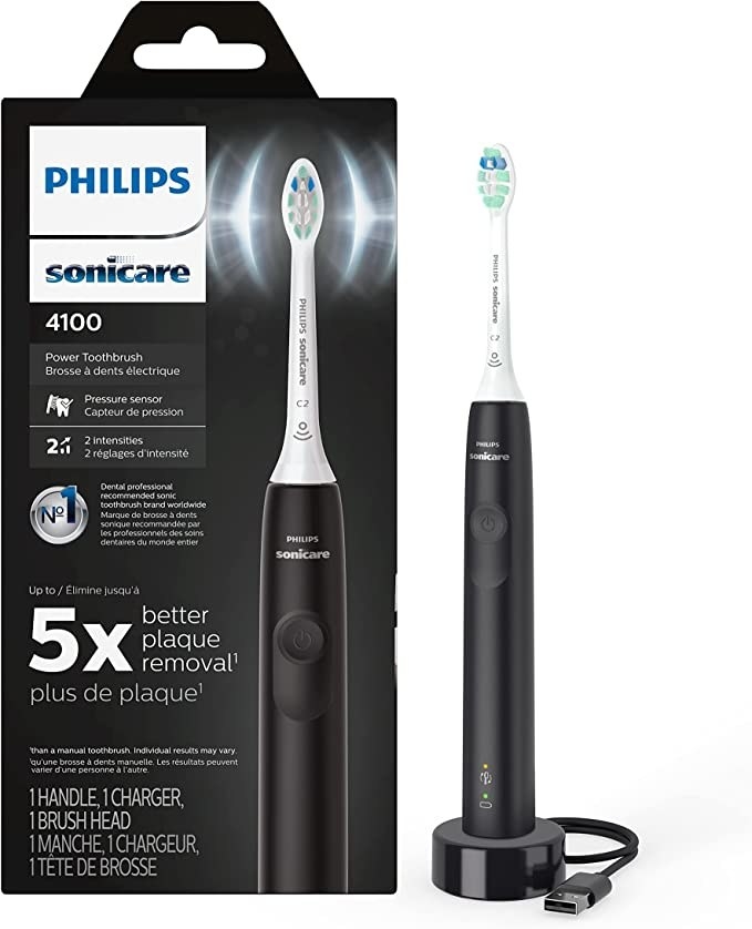 the toothbrush next to the box against a plain background