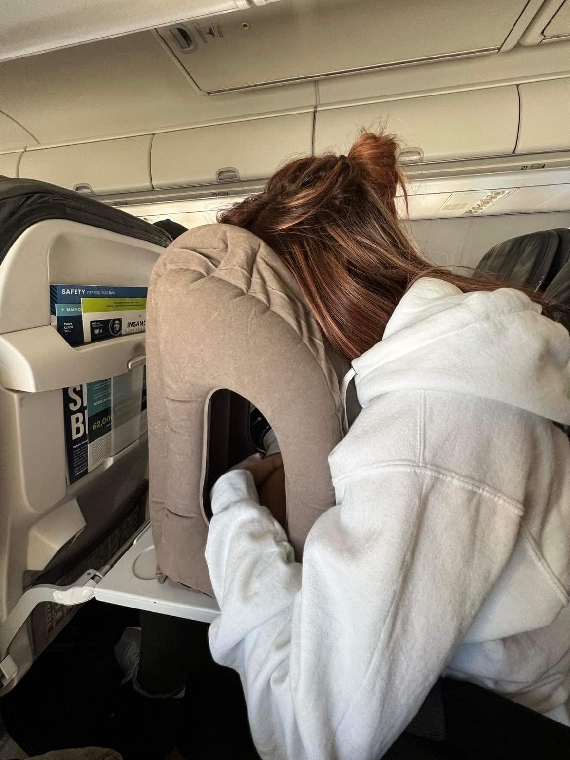 Reviewer using travel pillow on a plane