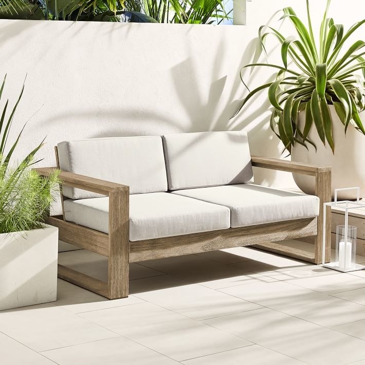 a white cushioned wood loveseat