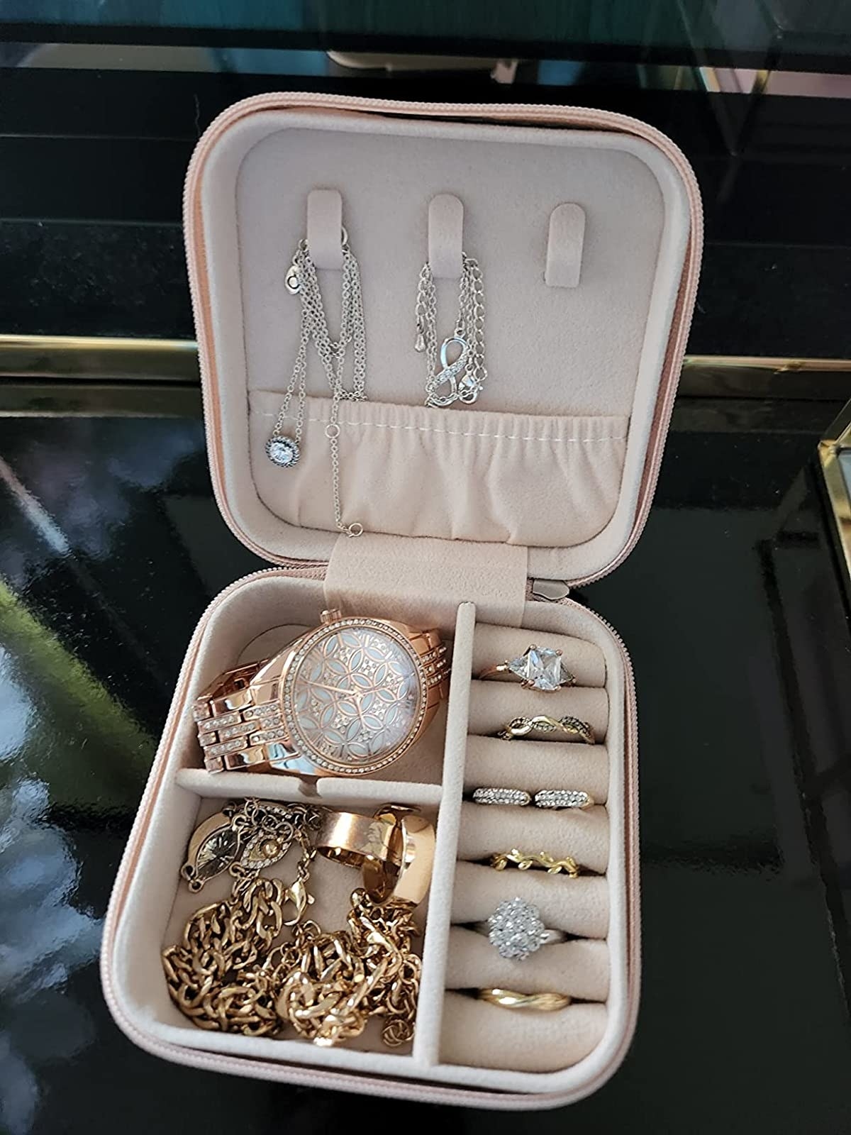 Reviewer image of jewelry case filled with rings, necklaces and a watch