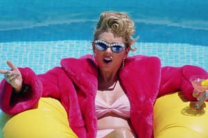 Taylor Swift sits on a pool floatie with a drink in hand