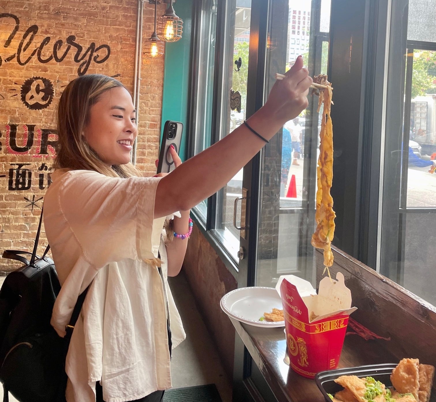a person grabbing noodles with chopsticks