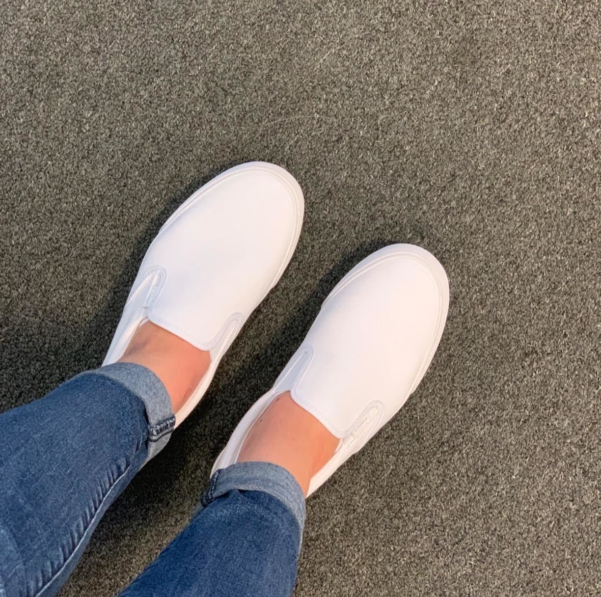 Reviewer wearing jeans and white slip on shoes