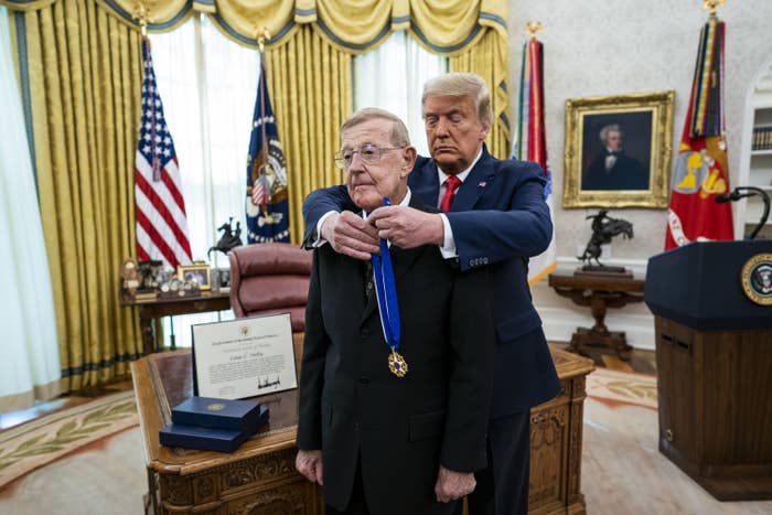Former President Trump placing a medal around a man&#x27;s neck