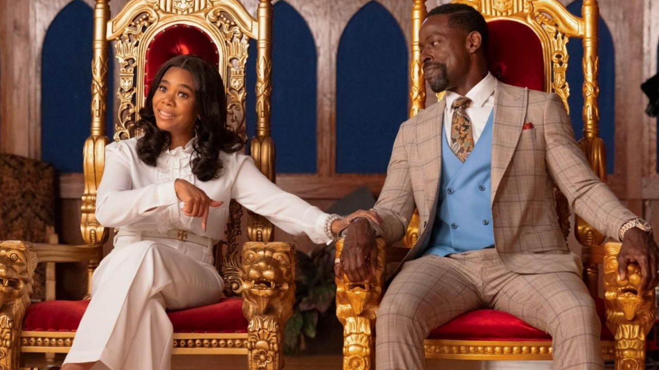 A man and a woman dressed in business attire sit on golden thrones