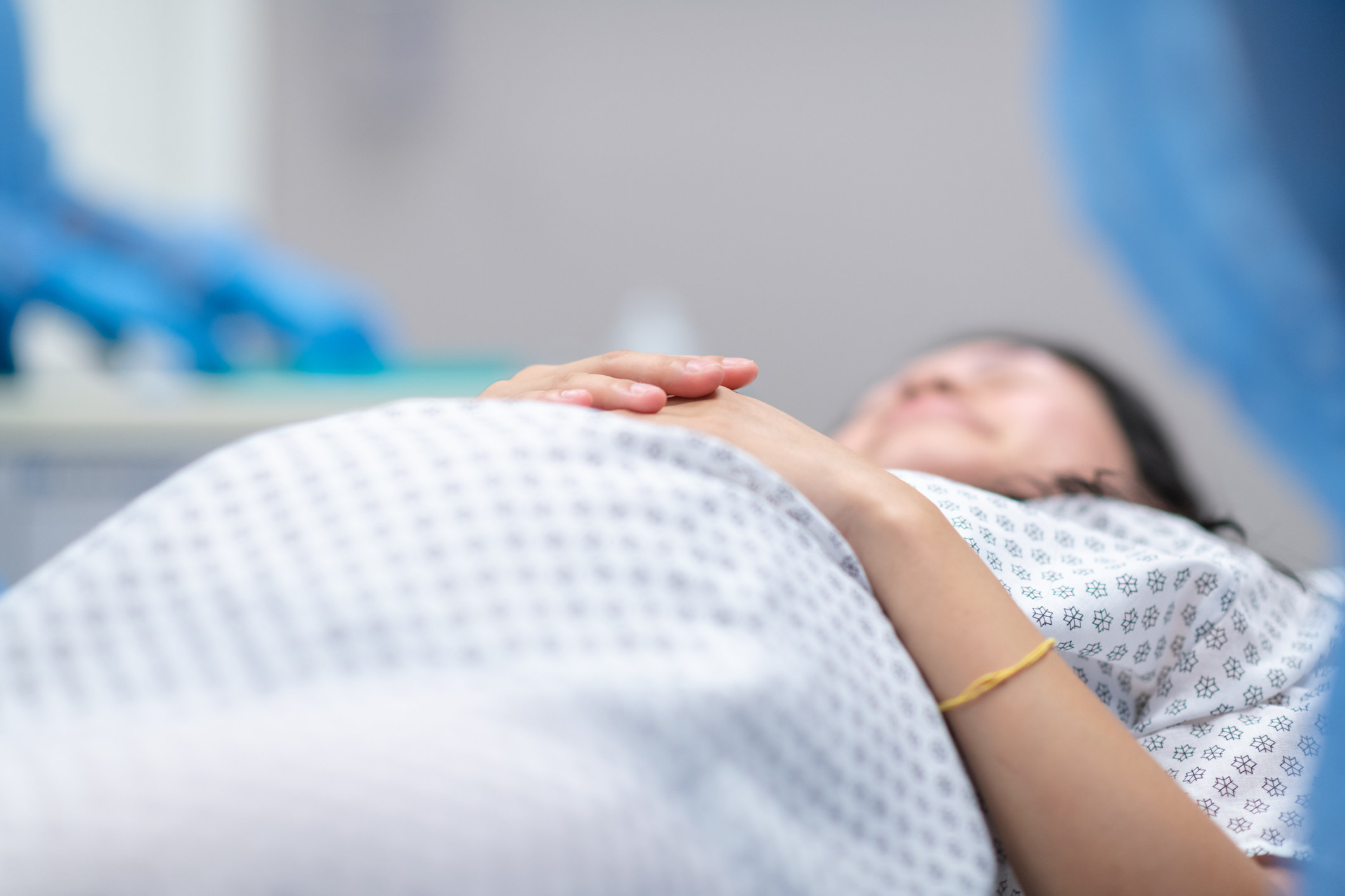 A pregnant person lies on an operating table