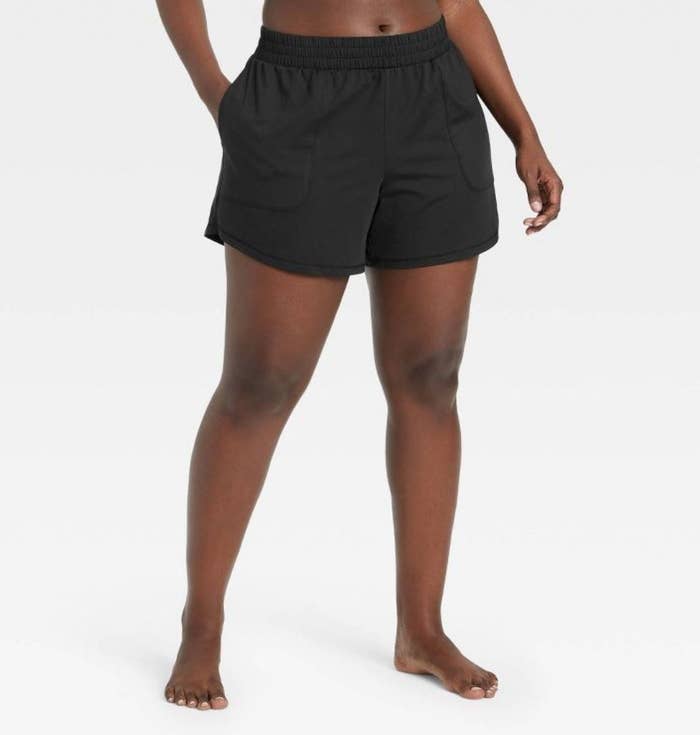 model wearing black mid-rise active shorts