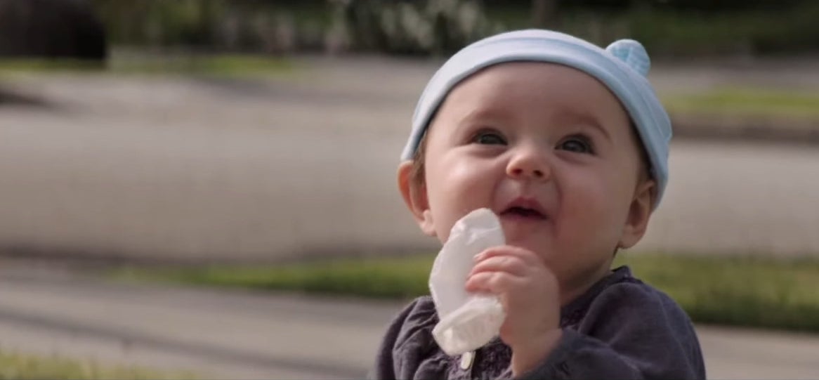 A baby holding a used condom