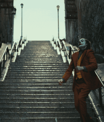 Joaquin Phoenix dances down a staircase in the movie Joker