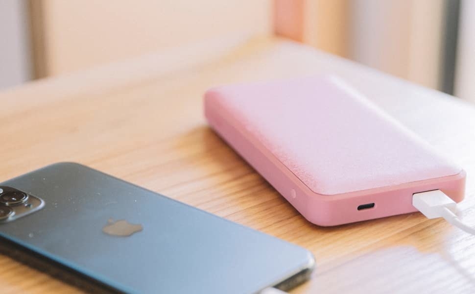 the power bank in pink charging an iPhone