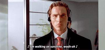 Christian Bale as Patrick Bateman walking through an office and listening to upbeat music