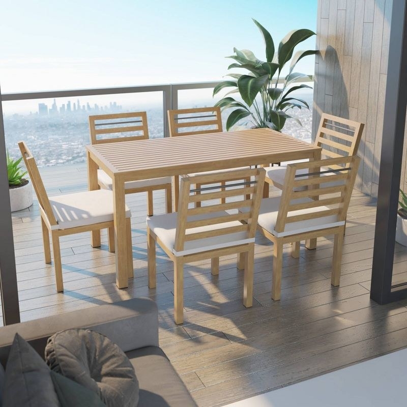 a seven-piece acacia table and chair set on a balcony