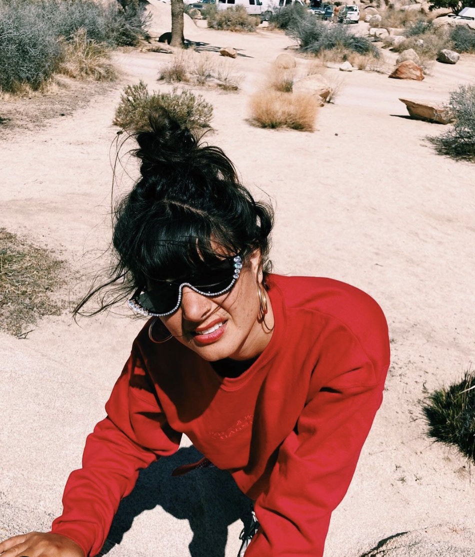 Arielle wearing sunglasses and a long-sleeved shirt in the desert