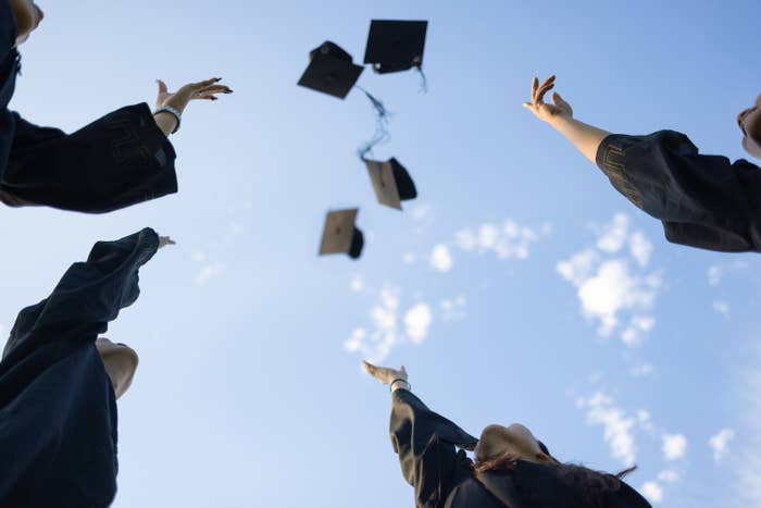 Students tossing graduation caps into the air