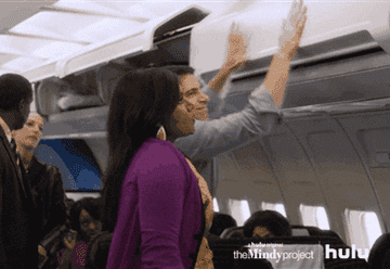 Mindy Kaling trying to close overhead bin