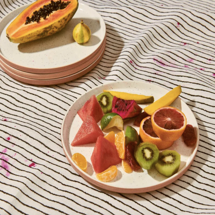 stacked pink plate set with fruit on top