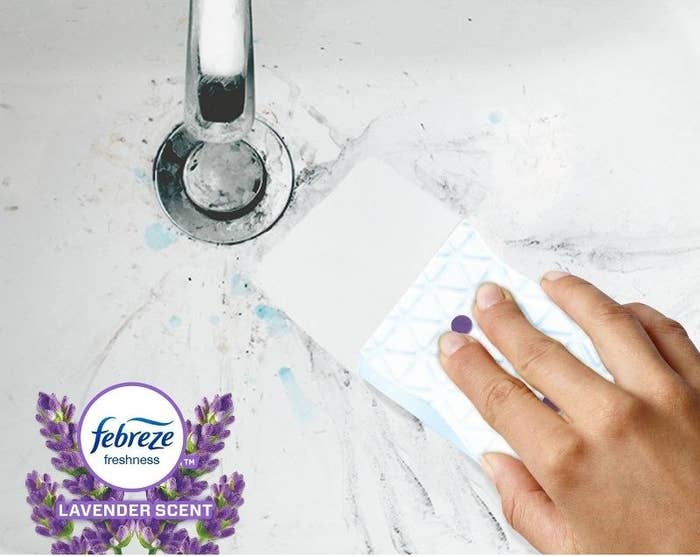 a person using a magic eraser to clean a white sink