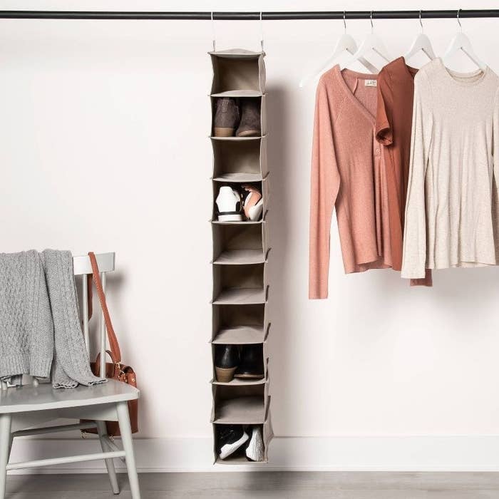 a gray ten-shelf hanging shoe storage organizer hanging in a closet