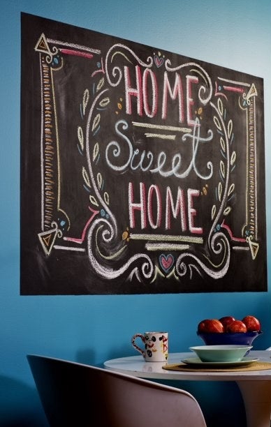 The chalkboard paint used on a wall with the message Home Sweet Home written on it in chalk