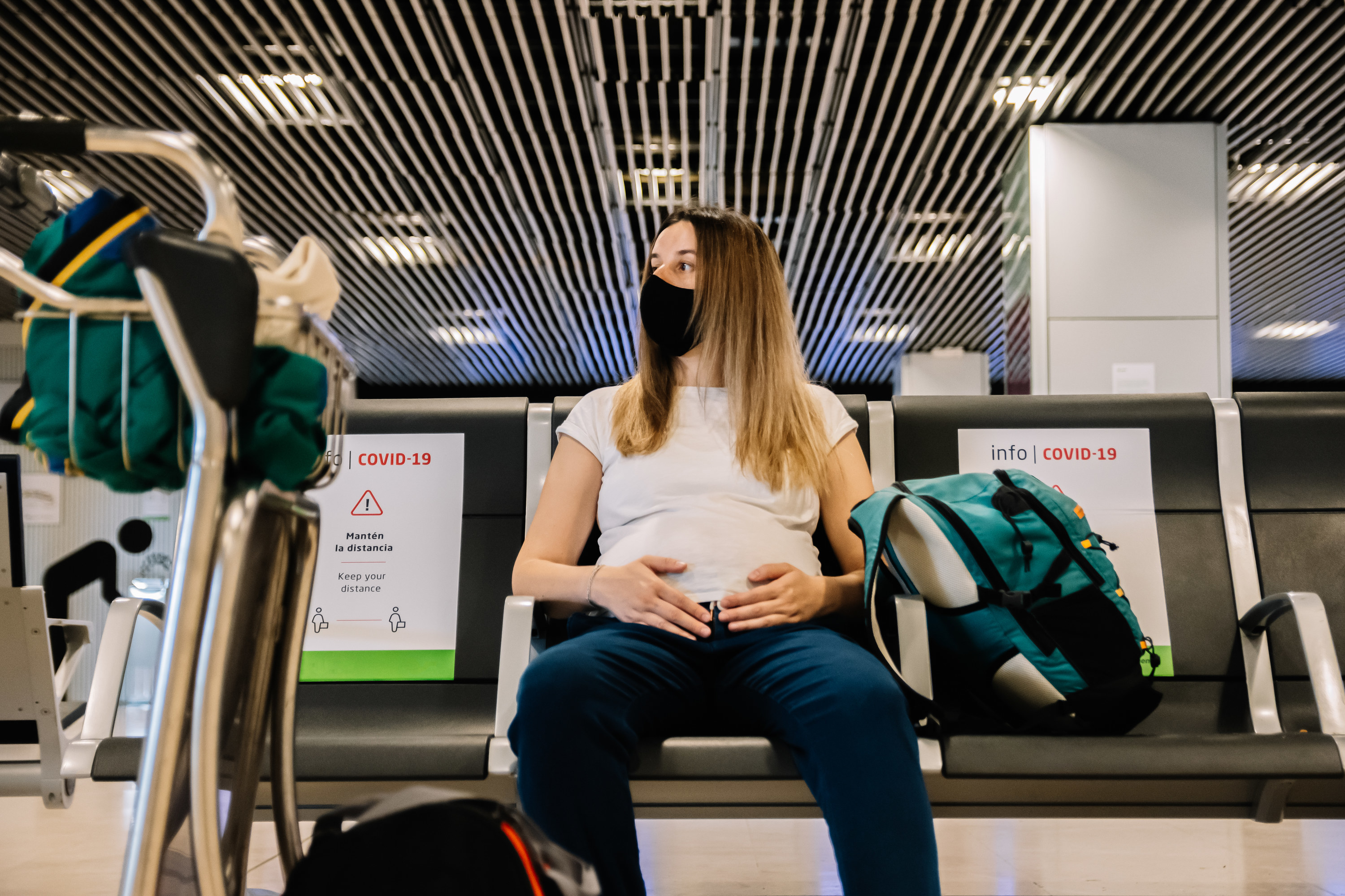 pregnant woman sitting down at airport
