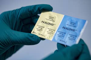 一个人拿着辉瑞制药公司的药物Paxlovid。