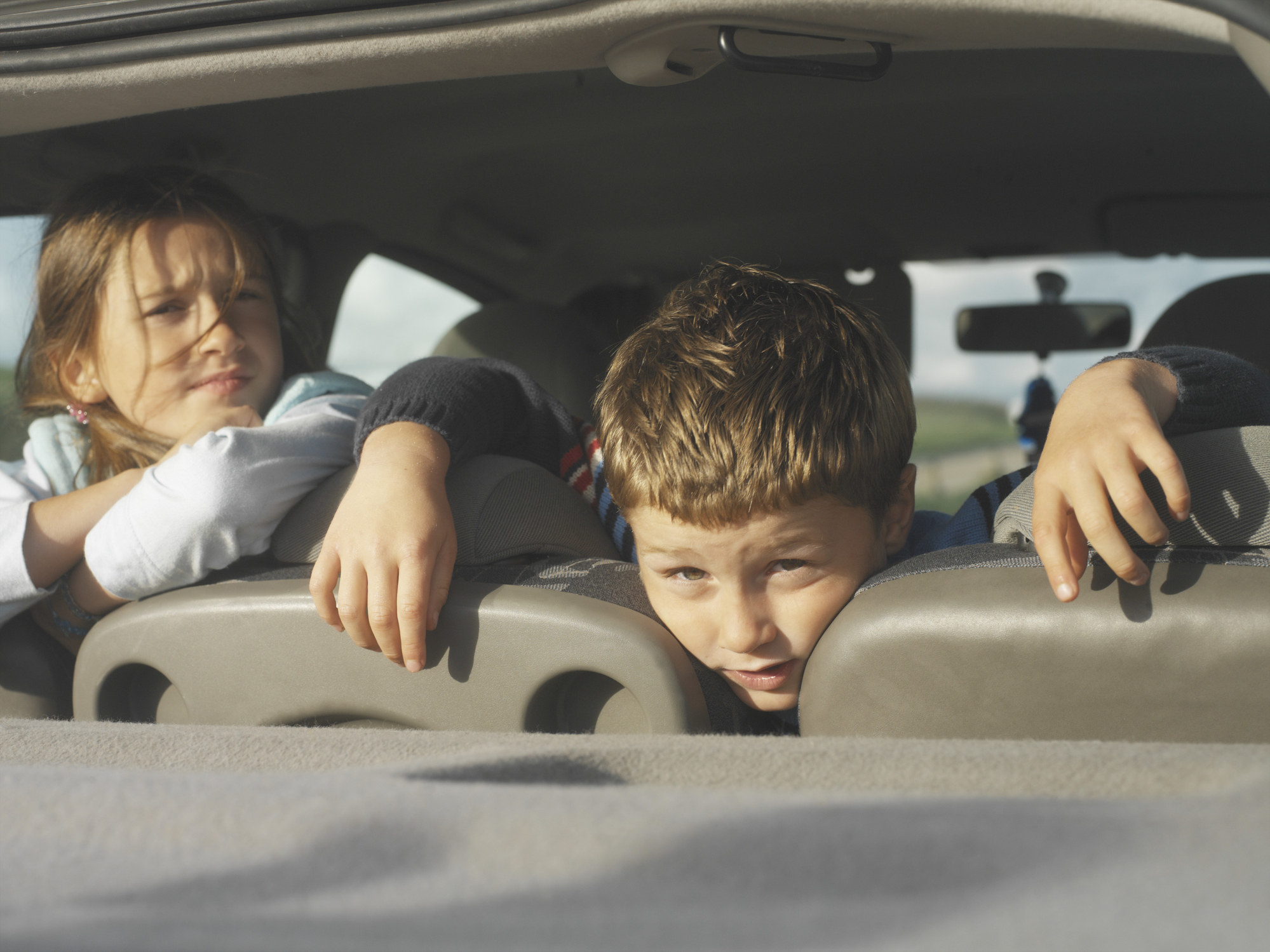 kids looking out the back of the car