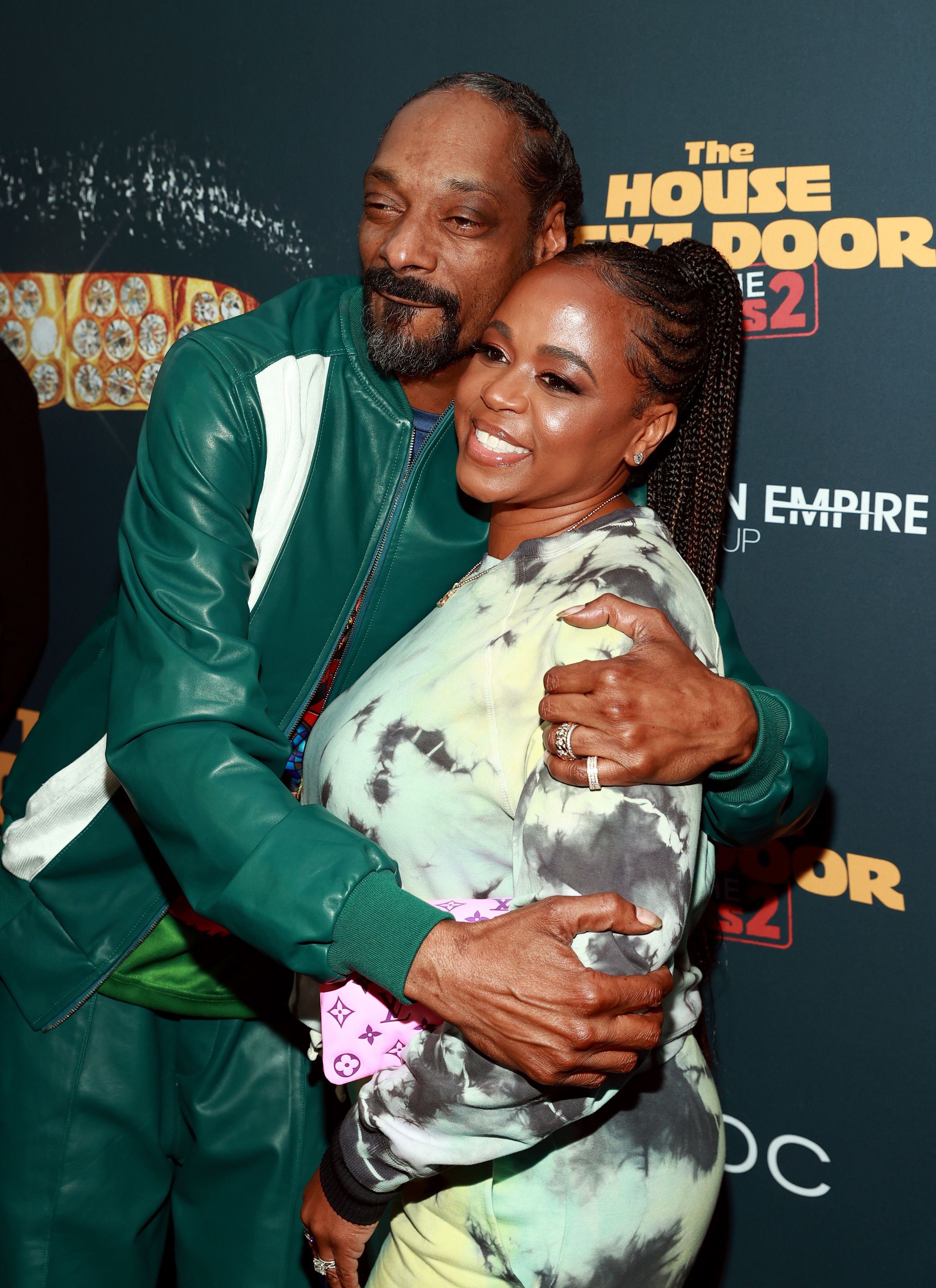 Snoop Dogg and Shante Broadus both wearing green track suits and posing for the camera