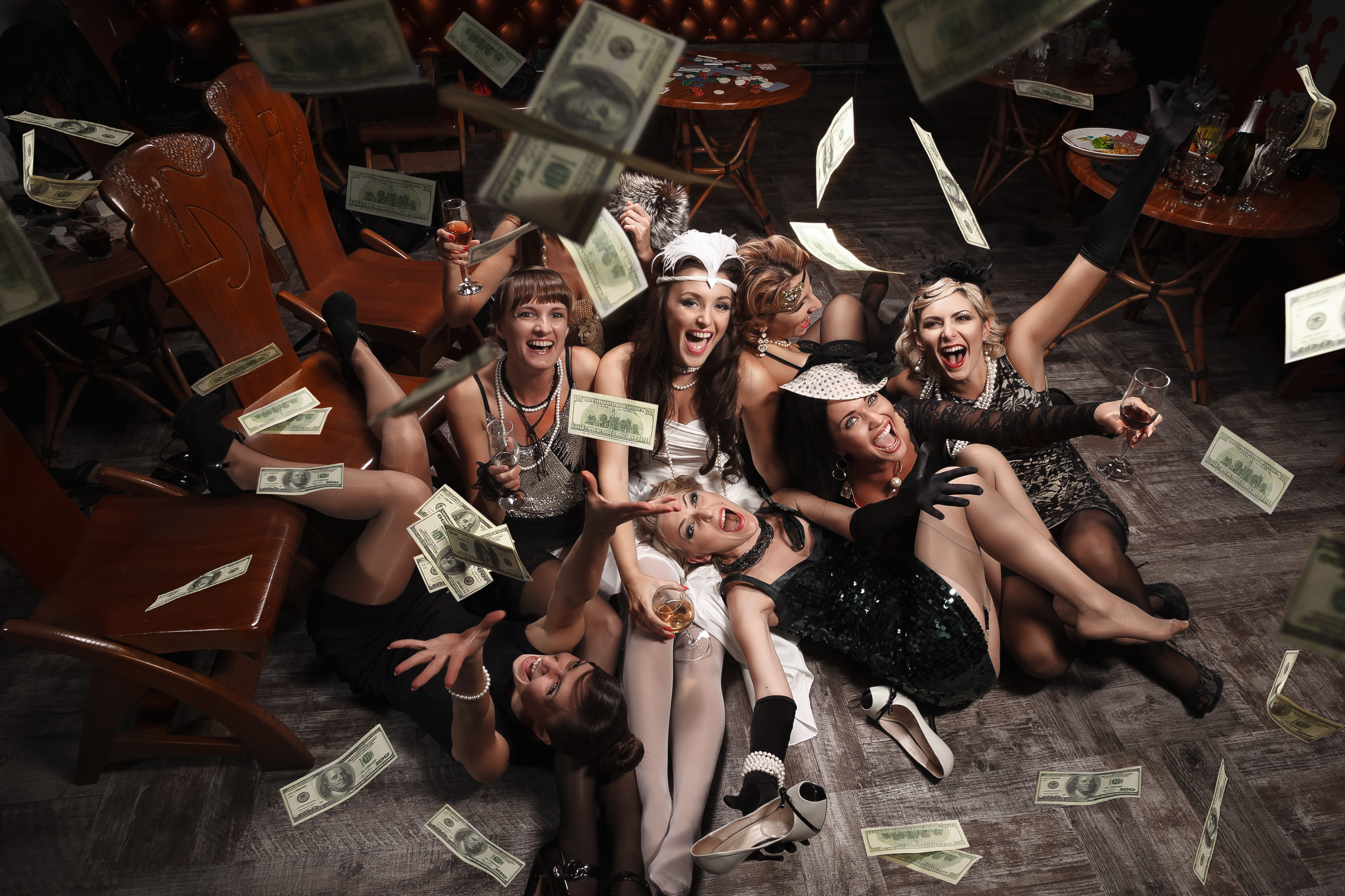 Women through money in the air at a bachelorette party
