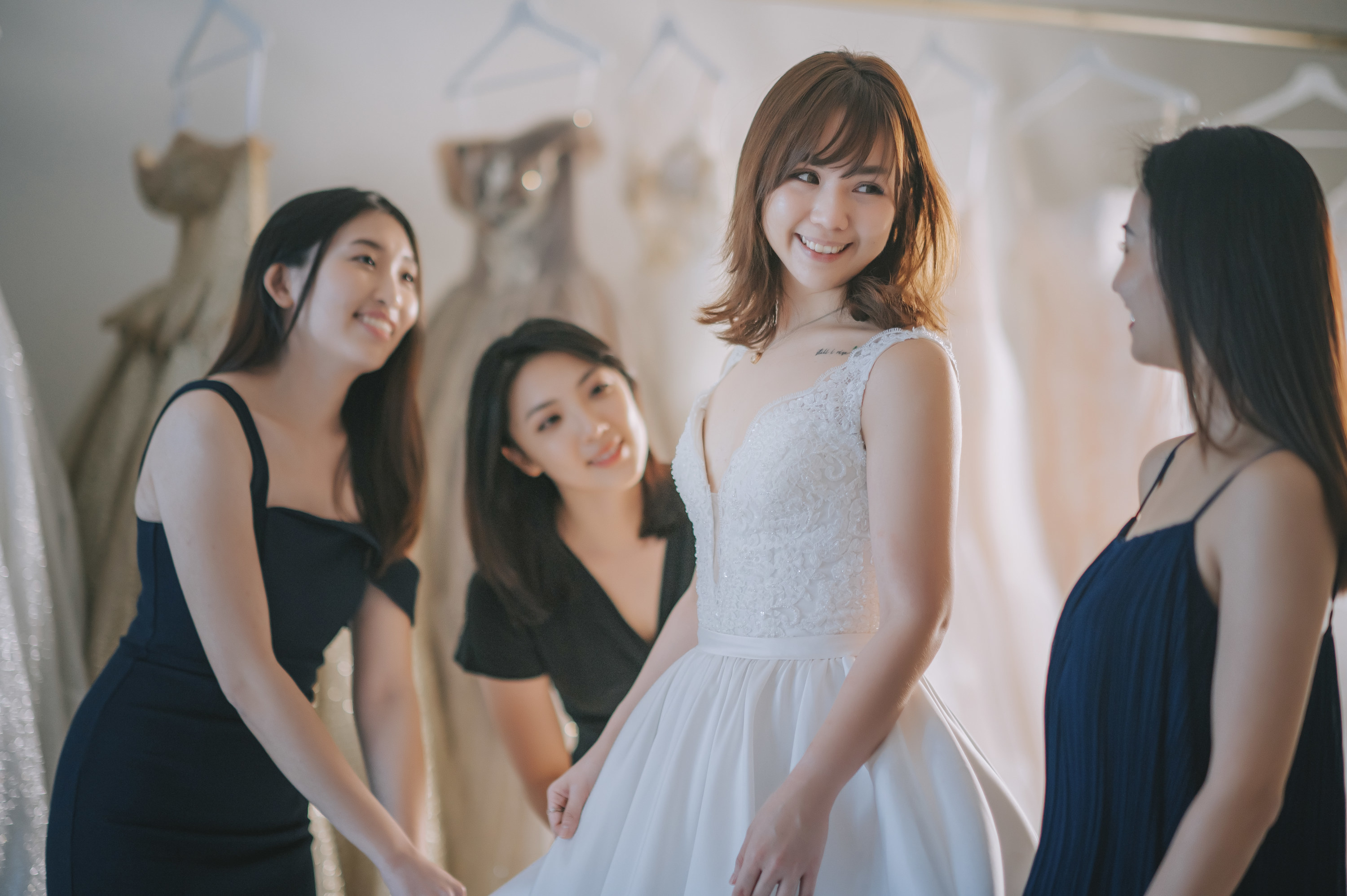 Bride in her wedding gown smiles, next to her bridesmaids
