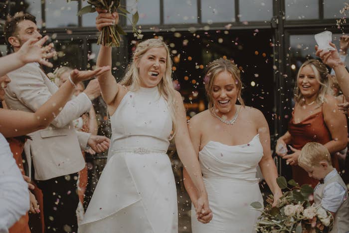 Two women just married surrounded by friends and family