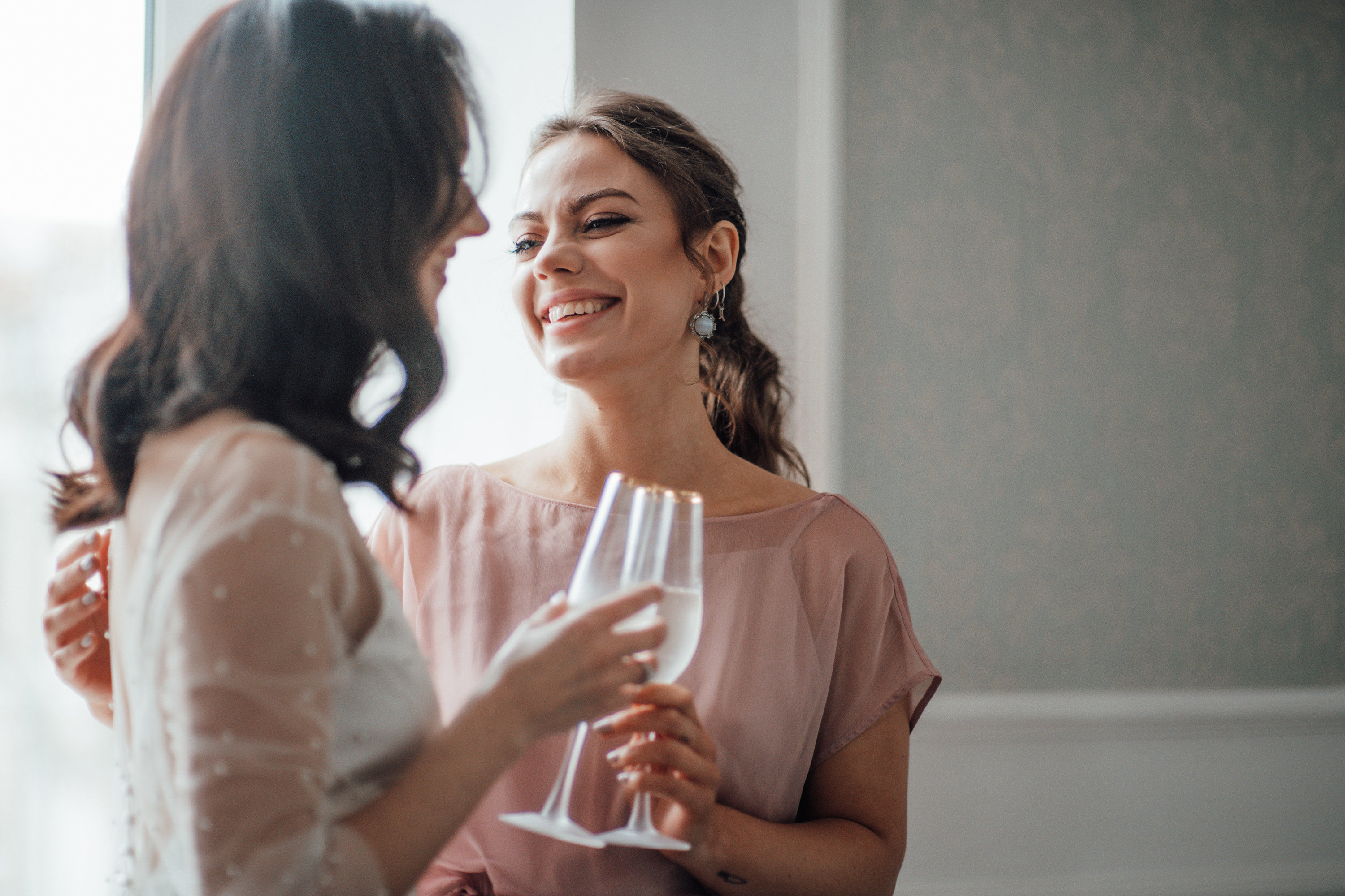 Maid of honor toasts champagne glass with the bride