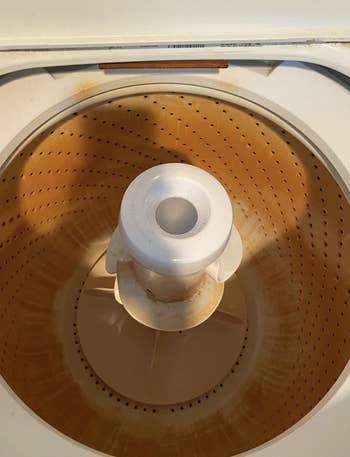 inside of a reviewer's washing machine looking rusty and orange
