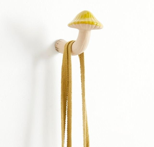 Yellow and white mushroom hook that looks like it's growing out of the wall