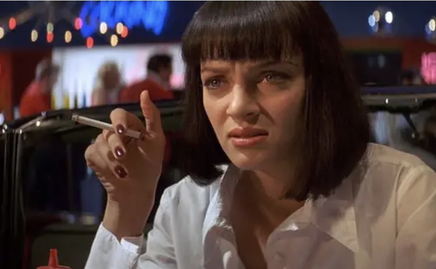 Uma Thurman as Mia in the movie holding a cigarette