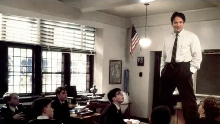 Robin Williams standing on a chair in a scene from the movie