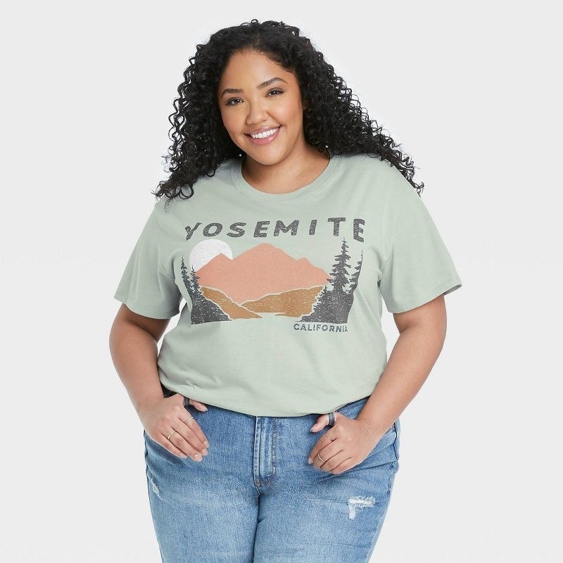 model wearing light green graphic tee with mountains and &quot;yosemite&quot; on it