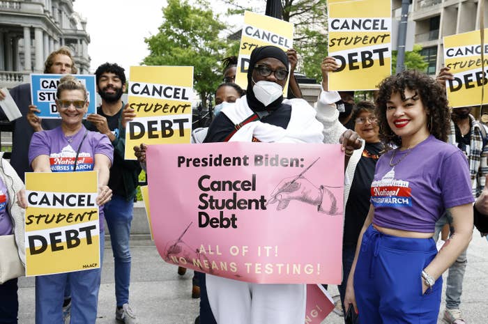 demonstrators with signs that say cancel student debt