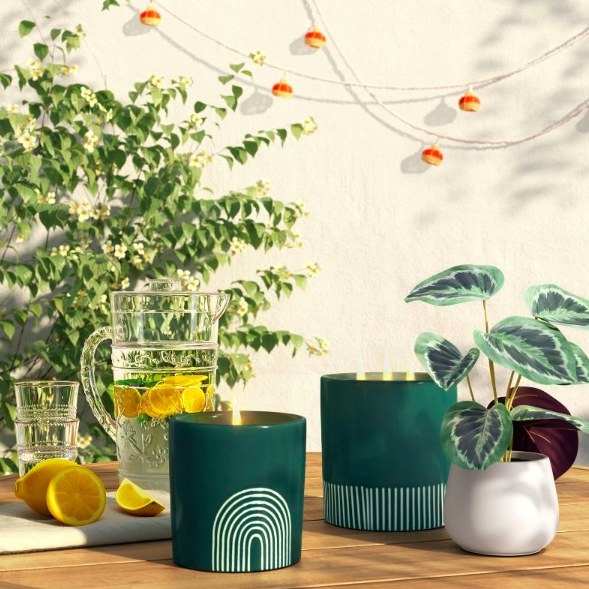 The green candle on a table outside with other decor