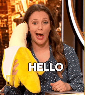 Drew Barrymore holding a big banana and saying, &quot;Hello.&quot;
