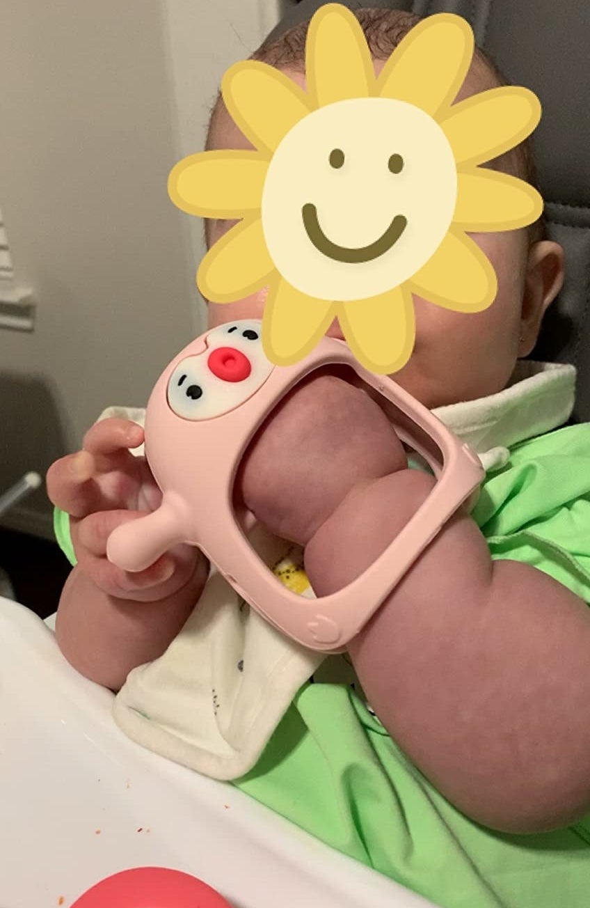 reviewer&#x27;s photo of baby with teething toy