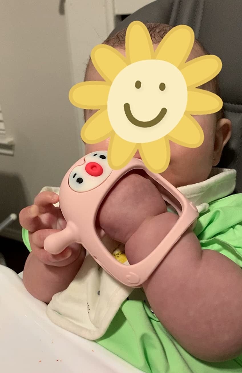 reviewer&#x27;s photo of baby with teething toy